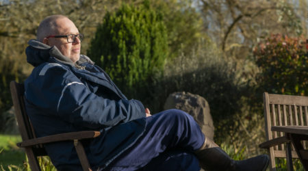 A older man sat on a park bench