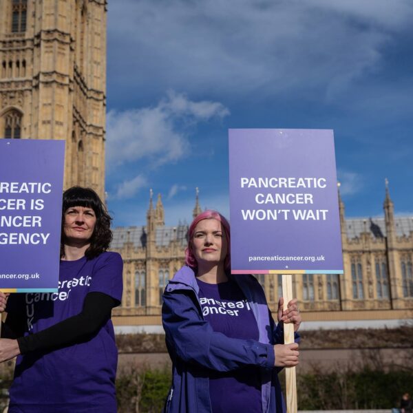 two ladies holding signs about pancreatic cancer