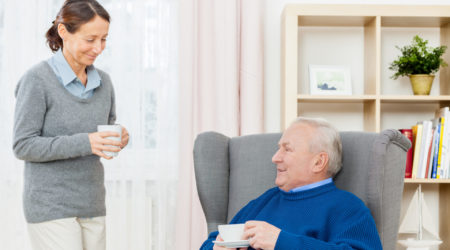 Man and woman talking, both holding a cup of tea