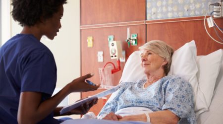 Nurse talking to a patient in a hospital bed