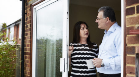 Man and lady talking to each other by their patio door