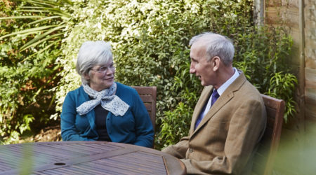 Older couple sat at a table in the garden
