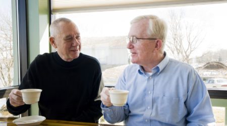 Two men drinking tea, sat at a table, talking