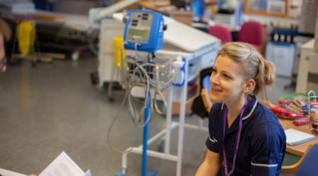 A nurse talking to someone in a hospital setting.