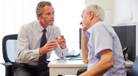 Senior Patient Having Consultation With Doctor In Office