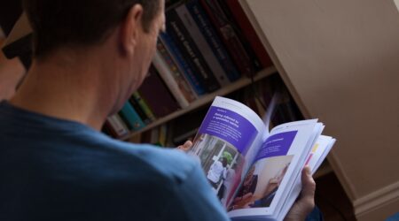 A man reading a PCUK booklet