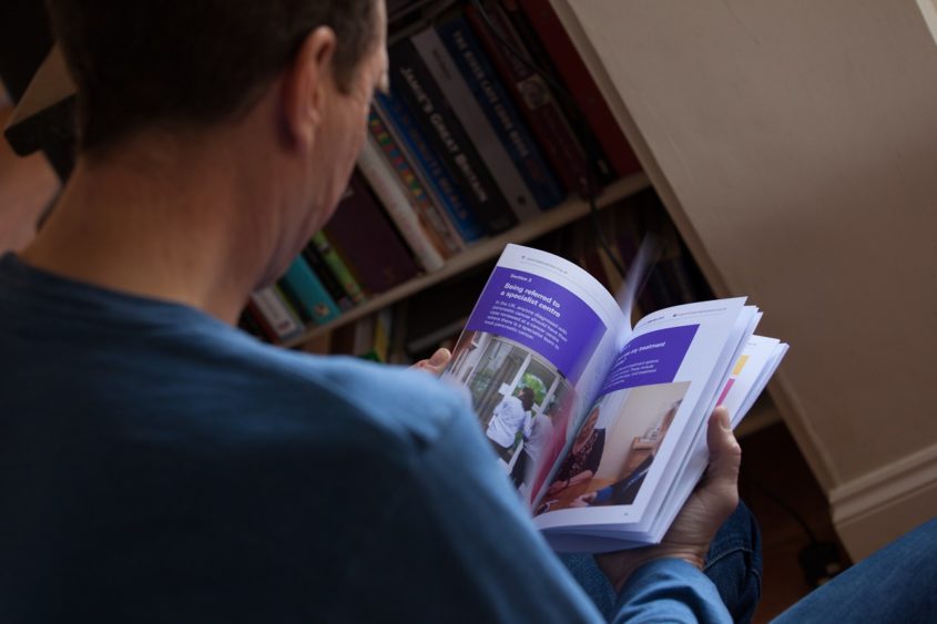 A man reading a PCUK booklet