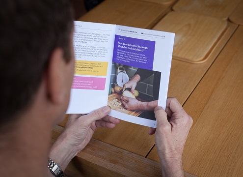 A man looking through a PCUK booklet