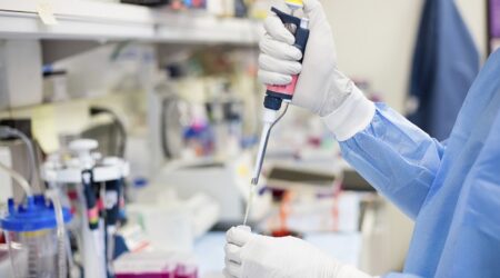 Scientist pipetting with hands in a laboratory