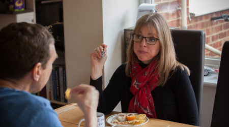 A lady eating sushi at the dining table with her husband