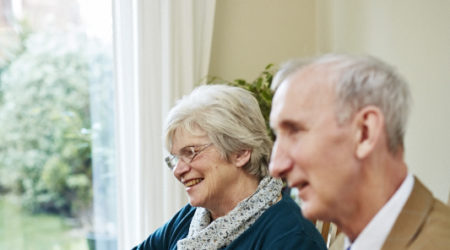 Older couple at a dining room table having a cup of tea