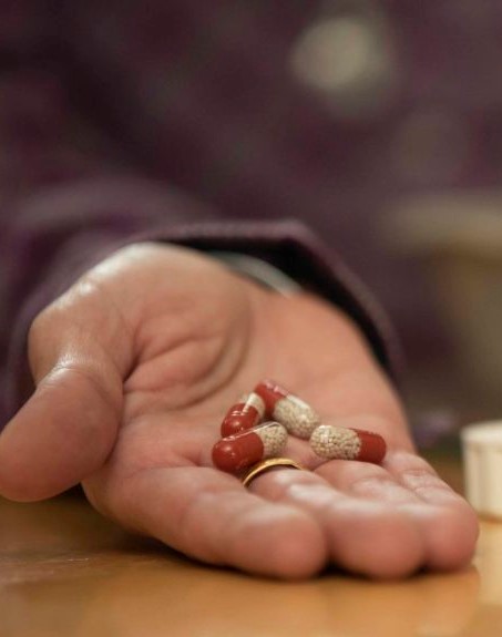 PERT capsules held in someone's hand