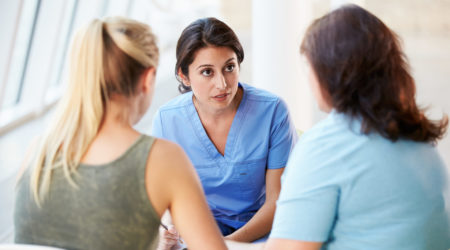 Two women talking to a nurse