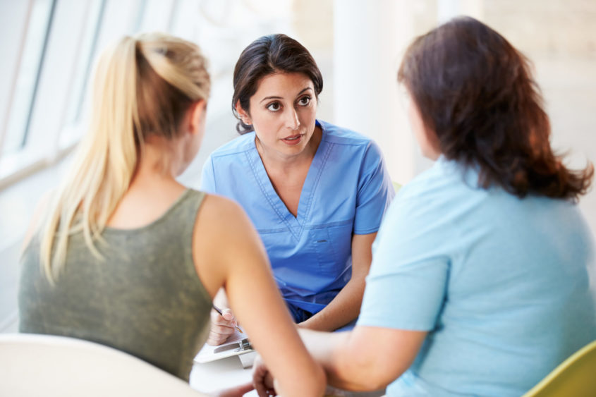 Two women talking to a nurse