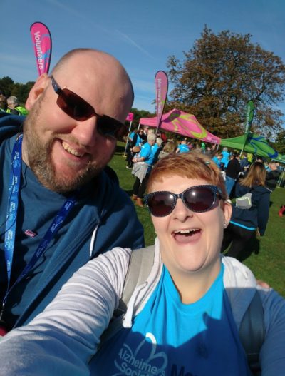 A man and woman smile for a selfie at a charity fundraiser.