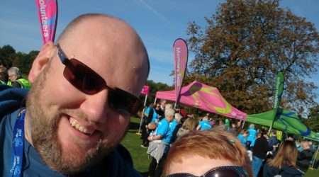 A man and woman smile for a selfie at a charity fundraiser.