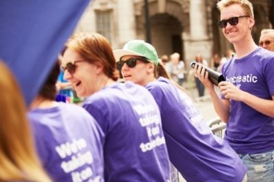 Group of people wearing pancreatic cancer UK t-shirts facing away from camera smiling