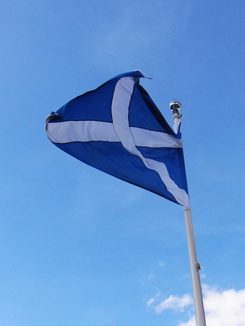 The Scottish flag flying against a blue sky.