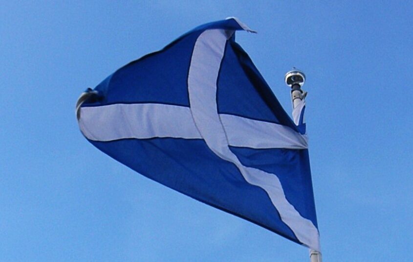 The Scottish flag flying against a blue sky.
