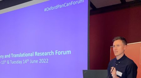 Pancreatic Cancer UK's Head of Research, Chris Macdonald standing at a lectern presenting at the Discovery and Translational Research Forum