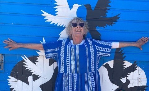 Jane Travers standing in front of a mural of doves