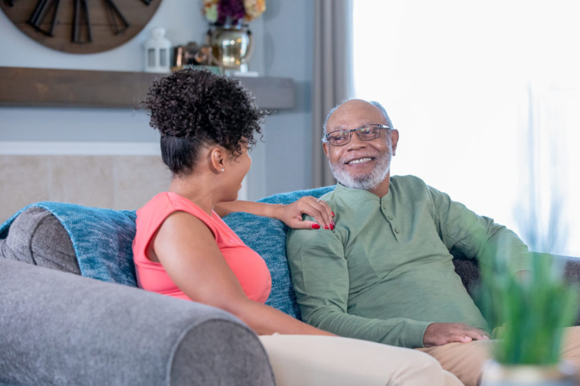 Adult woman visiting senior father in nursing home