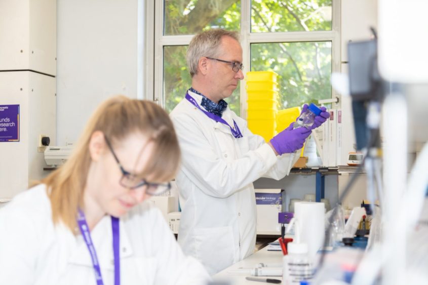 Scientist Professor Robin Ketteler working in a lab with one of his colleagues