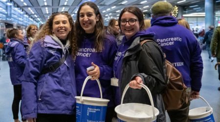 Volunteers smiling with collection buckets