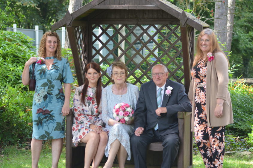 Anne and her husband Neil with family on their wedding day