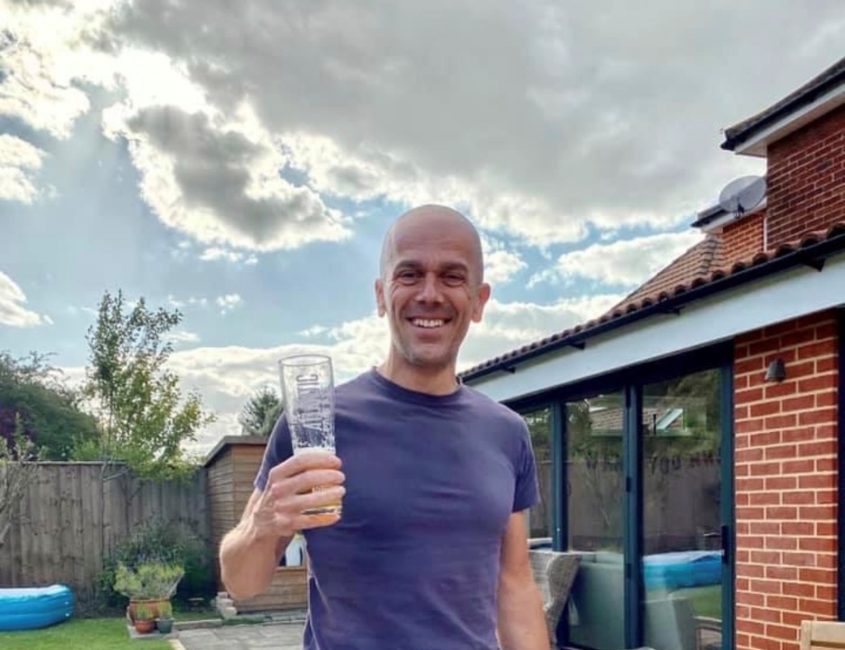 man in a garden holding a beer glass and smiling to camera- Phil