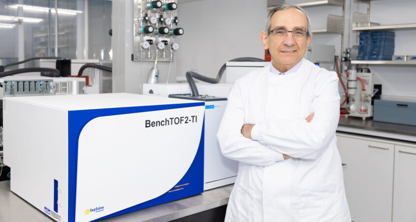Professor George Hanna standing in a lab wearing a white lab coat with his arms crossed looking at camera