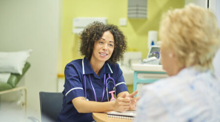 A female nurse talks to a senior patient in the clinic triage