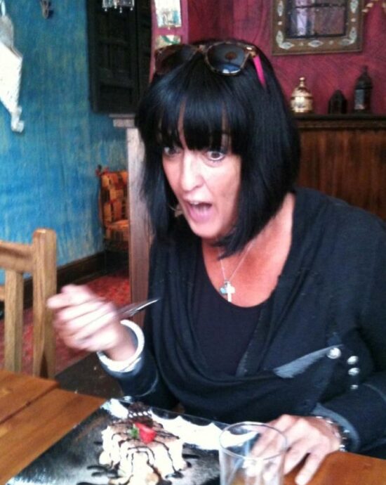 woman eating birthday cake with a surprised face