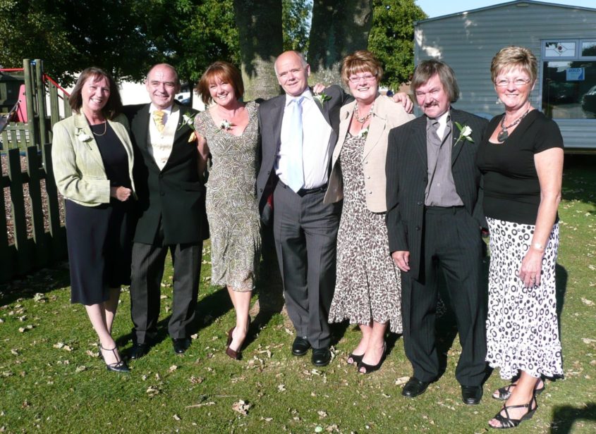 a group of people standing inline all wearing formal clothes - Elliot and Denise