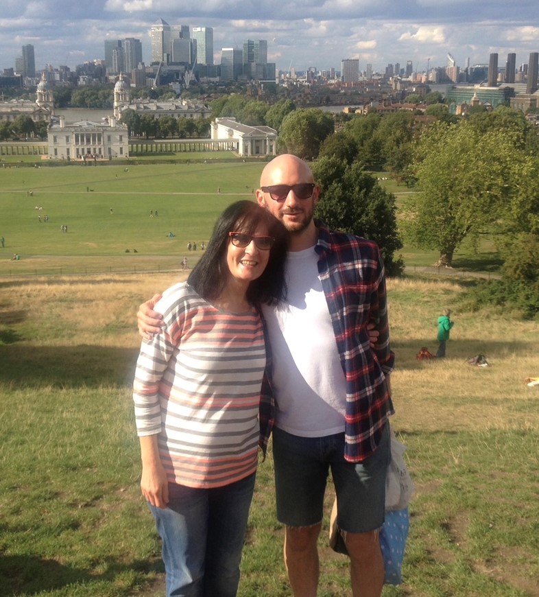 Man and woman standing on front of London skyline