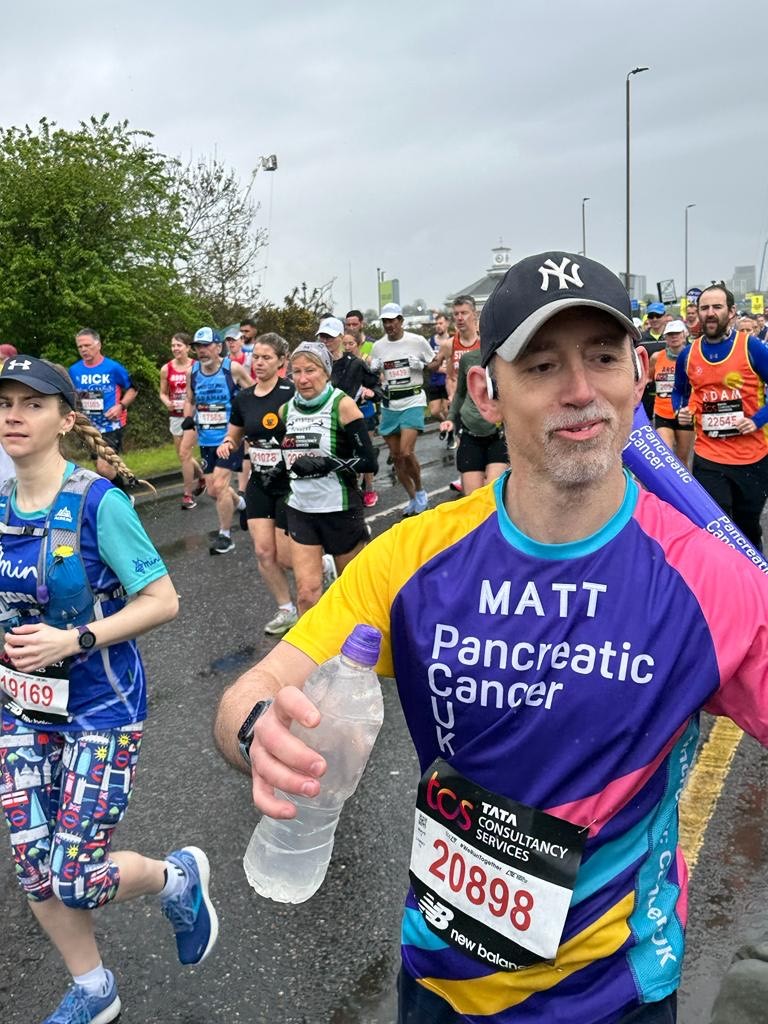 Person running on the track wearing a Pancreatic Cancer UK top