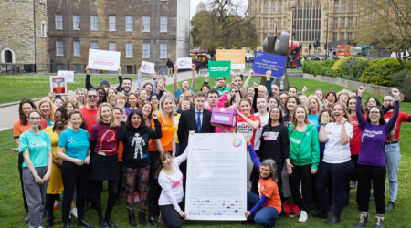 Large group show showing members of to the One Cancer Voice coalition on College Green, outside the Houses of Parliament