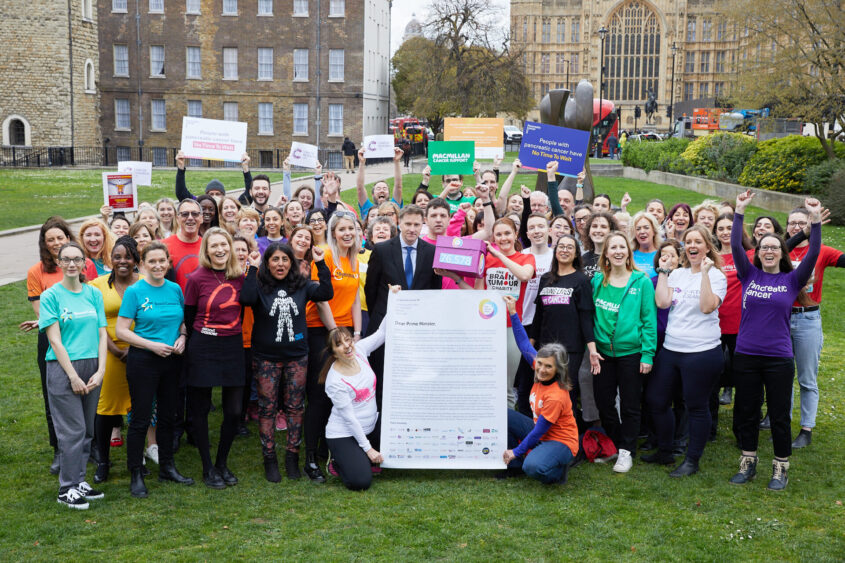 Large group show showing members of to the One Cancer Voice coalition on College Green, outside the Houses of Parliament