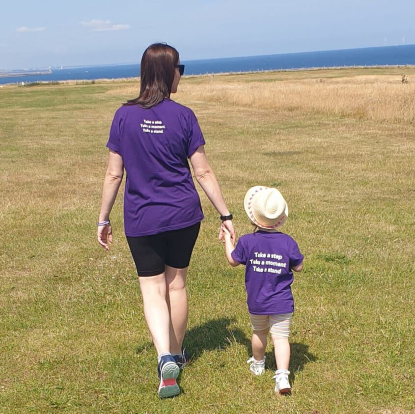 Sharon and her daughter Erin walking on grass