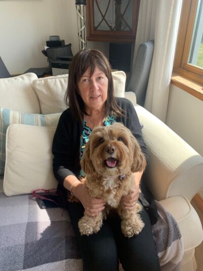 Woman on sofa holding a dog.