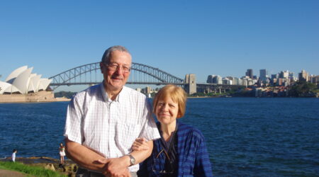 John and his wife Natalie standing in front of the Sydney Opera House and bridge