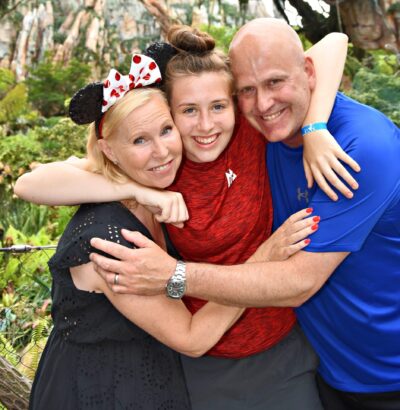 family of three all holding each other and smiling