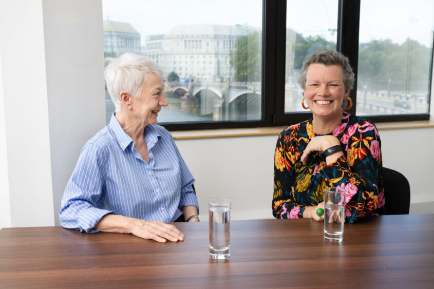 Maggie Blanks, CEO of Pancreatic Cancer Research Fund, and Diana Jupp, CEO of Pancreatic Cancer UK, laughing together in a meeting room.