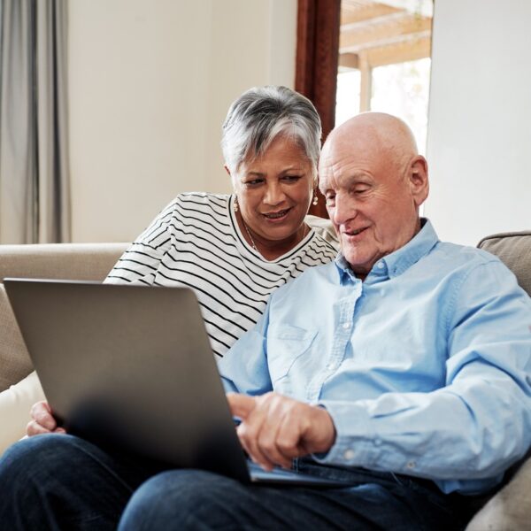 Couple looking at a laptop on the sofa