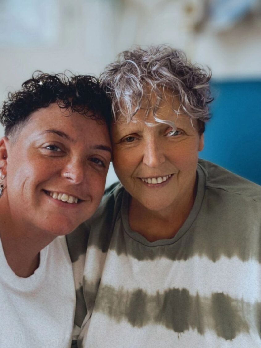 Selfie picture of woman with daughter both sitting and smiling to camera