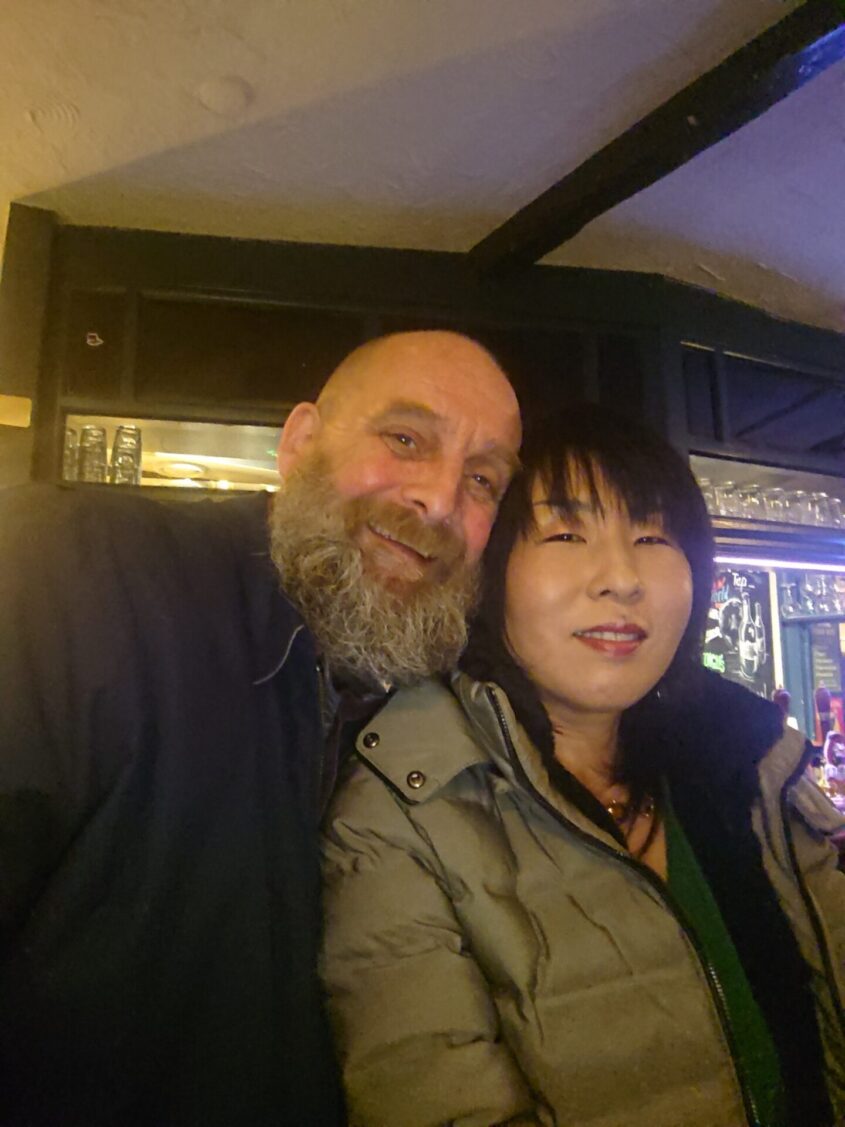 Man and woman in pub smiling at camera