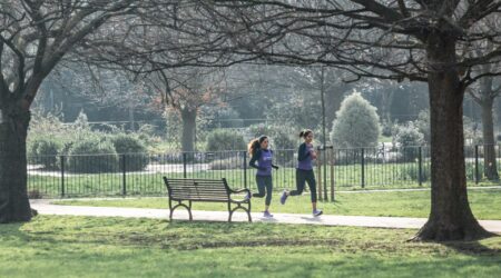 Two females running through a park