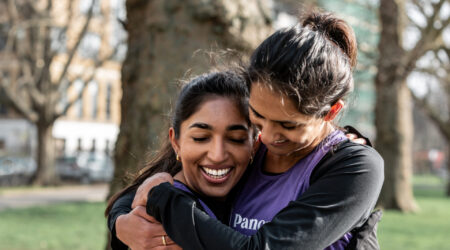 Two best friends, Alisha & Shriya, hug in Pancreatic Cancer UK vests