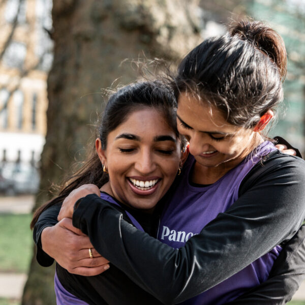 Two best friends, Alisha & Shriya, hug in Pancreatic Cancer UK vests