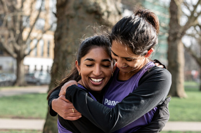 Two best friends, Alisha & Shriya, hug in Pancreatic Cancer UK vests